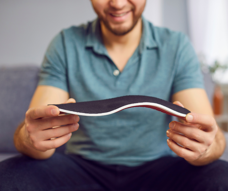 man holding custom orthotics